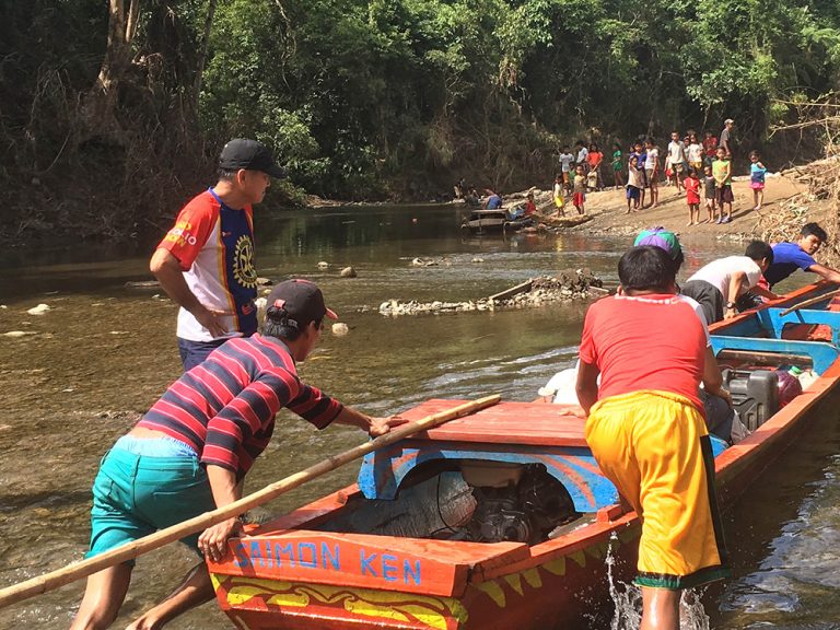 People pushing aid in a boat in the Philippines
