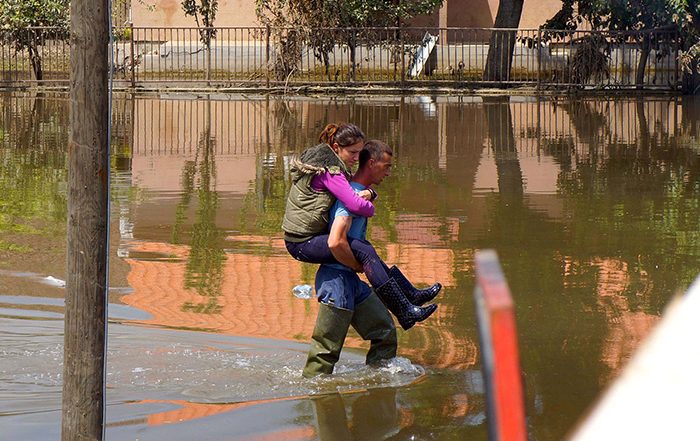 Man carries woman through floodwater in Serbia