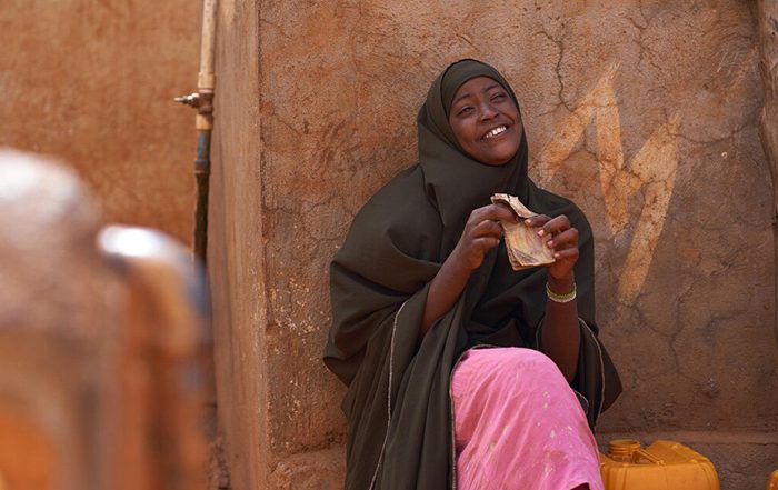 Woman smiling next to a shelter in Somalia