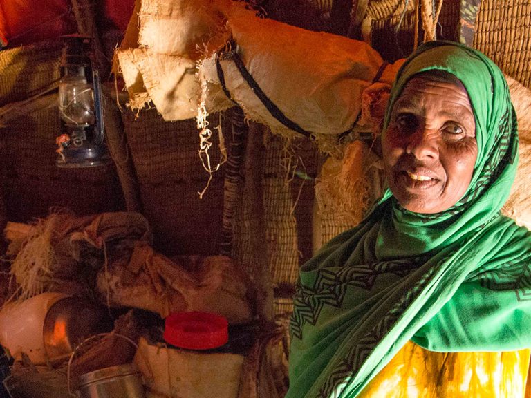 Woman wearing a green headscarf inside a shelter in Somaliland