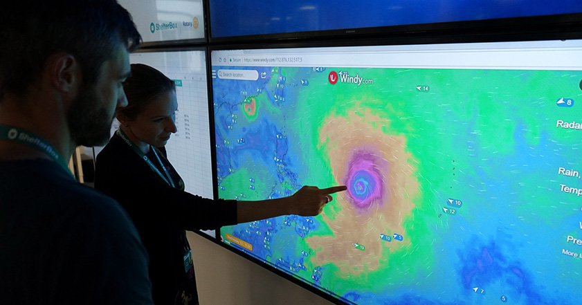 People monitoring a storm on a screen