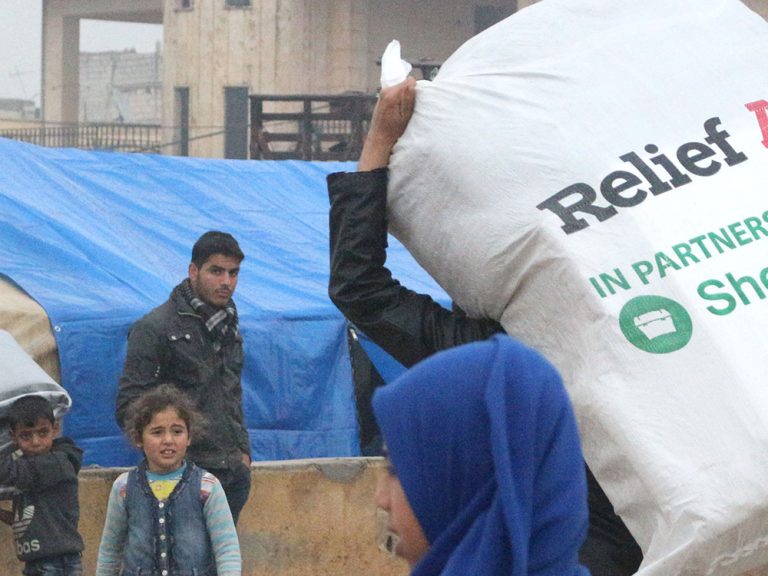 Person carrying bag of aid in Syria