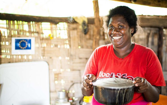 Woman smiling and holding a cooking pot in Vanuatu
