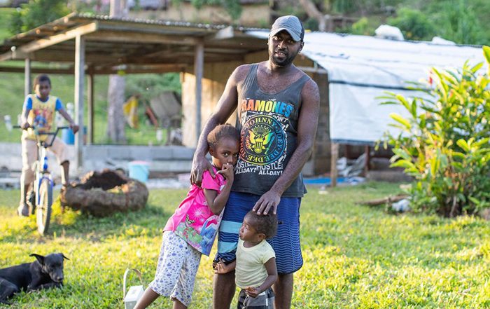 Man and children in front of a shelter in Vanuatu