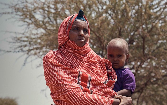 Woman in red headscarf holding a child in Somaliland