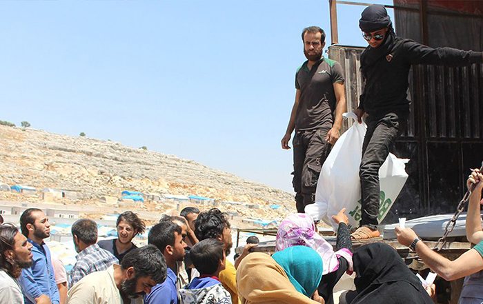 People receiving aid off a truck in Syria