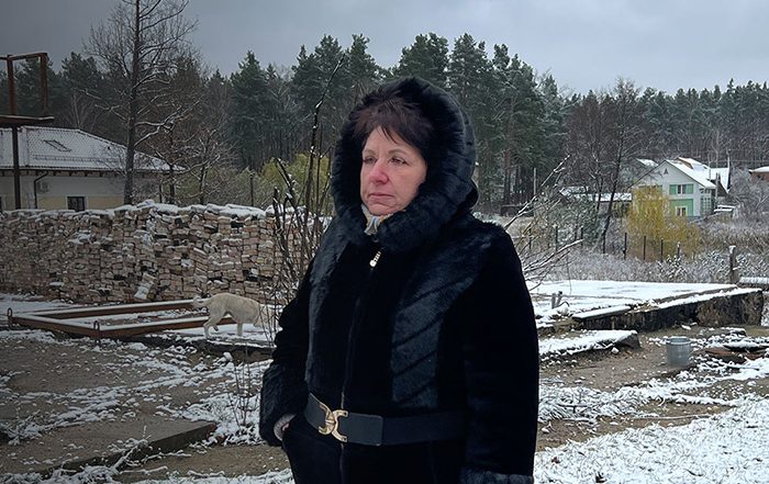 Woman standing in remains of destroyed houses in Ukraine