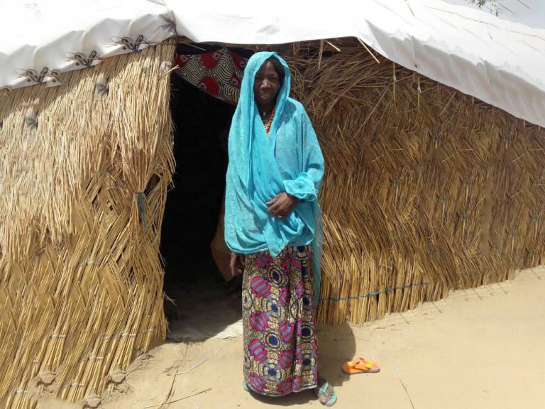 Woman in front of a home in Nigeria