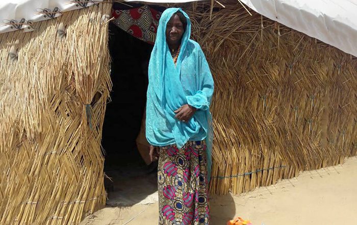 Woman in front of a house in Nigeria