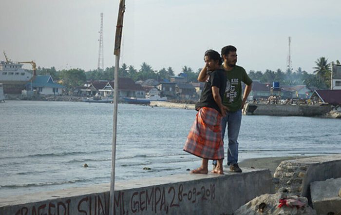 People standing on coast in Indonesia after a tsunami