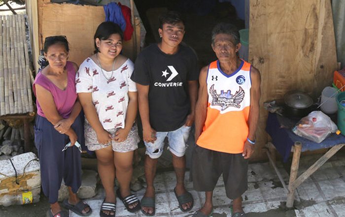 Family outside their shelter in the Philippines