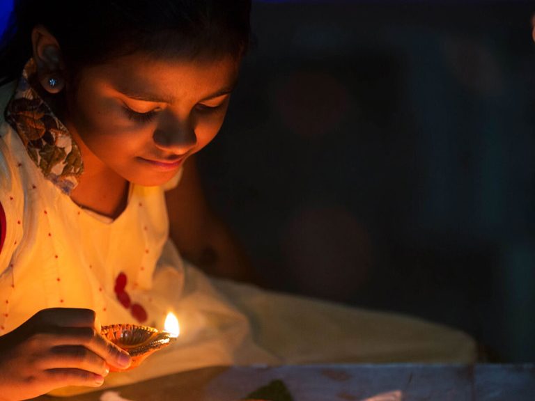 Girl lighting candle in the dark