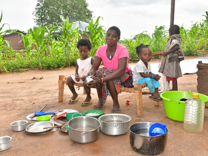 Woman and children sitting next to a kitchen set in Mozambique
