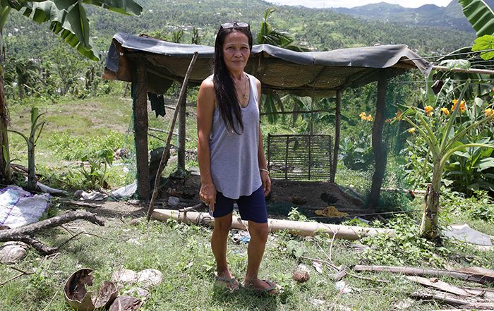 Woman standing next to damaged building in the Philippines