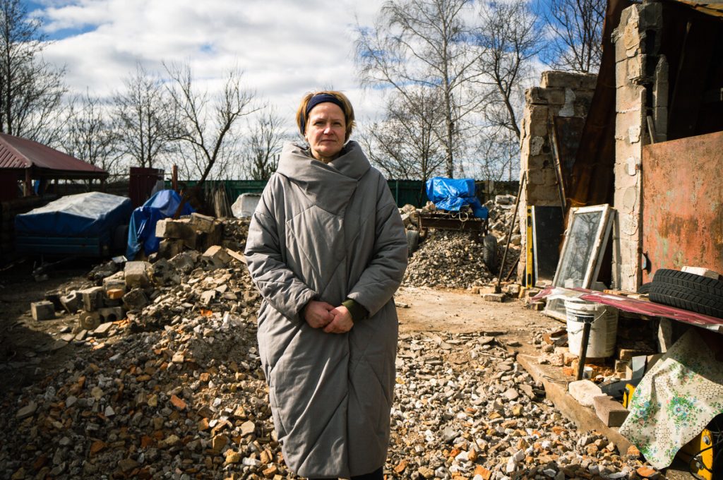 Women standing in remains of destroyed home in Ukraine