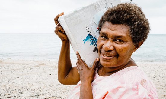Woman carrying bag of aid in Vanuatu