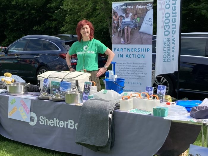 Woman behind table with a display about ShelterBox