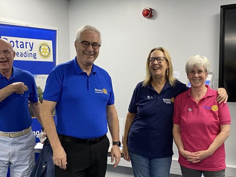 Four people next to Rotary and ShelterBox banners at a pop up event in Reading