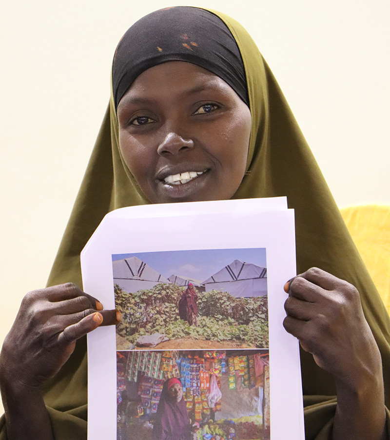 Woman holding piece of paper holding images of herself