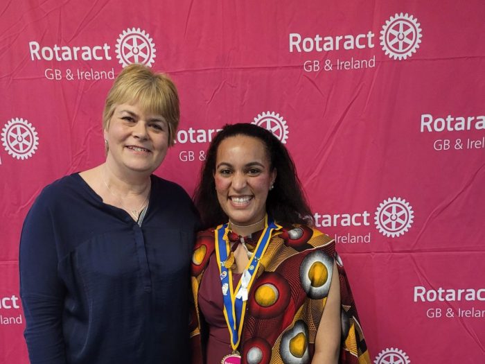 Two women in front of a Rotaract display