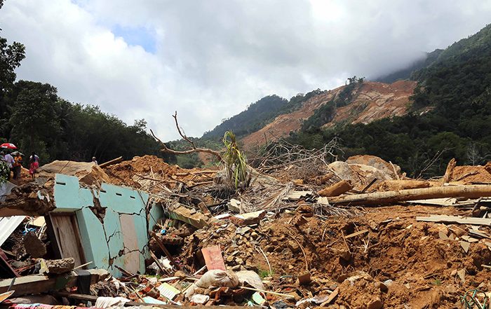 Hillside with marks left by landslide and debris at bottom of hill in Sri Lanka