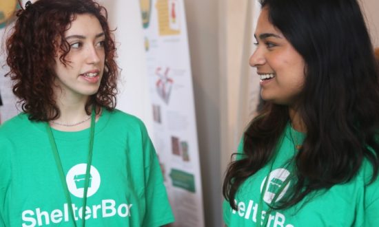 Two women in conversation wearing ShelterBox t-shirts