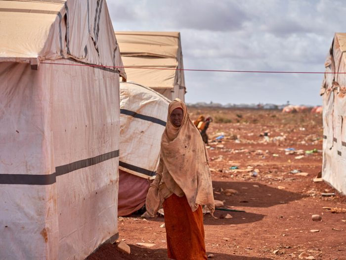 Woman among shelters in dusty landscape in Somalia