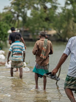 People wading through floodwaters in Bangaldesh