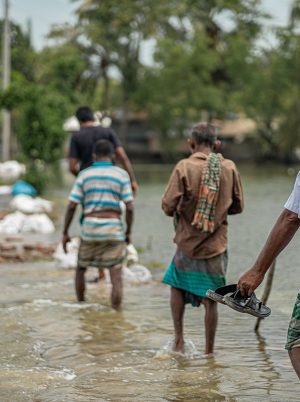 People wading through floodwater in Bangladesh