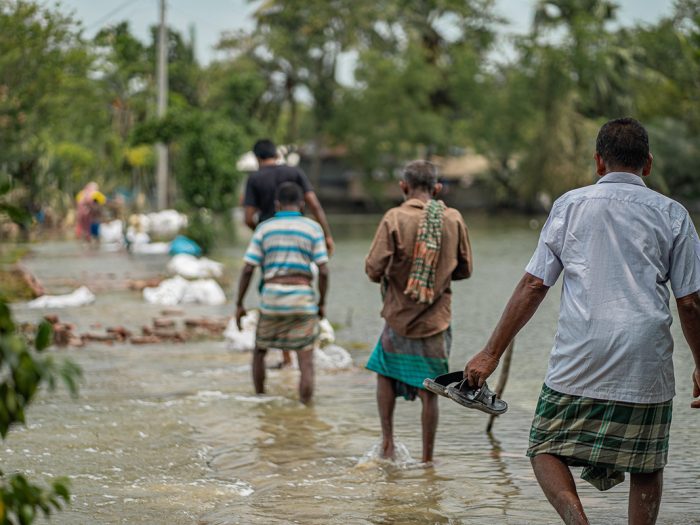 People wading through floodwater in Bangladesh