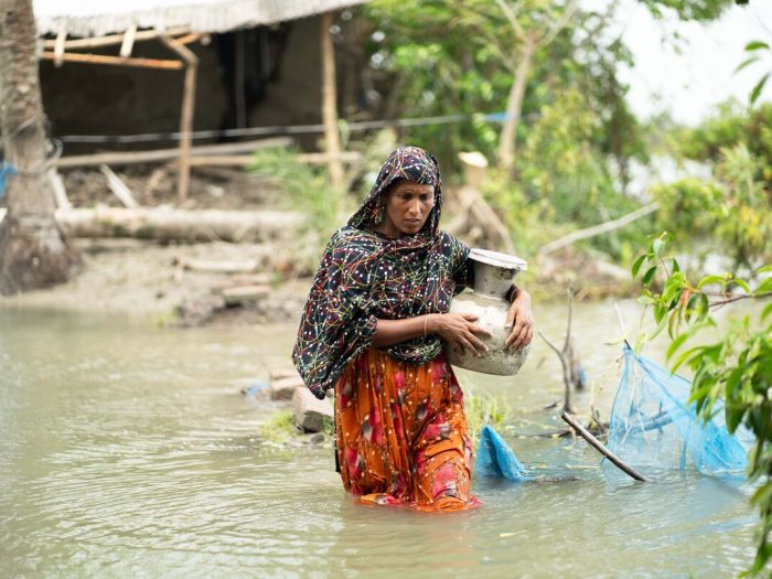 Woman wading through floodwater in Bangladesh