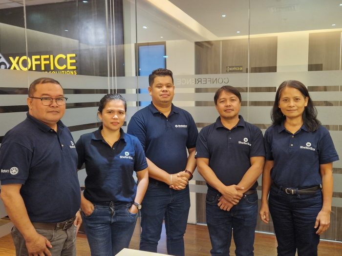 5 people wearing ShelterBox polo shirts