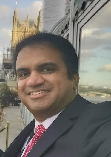 Man wearing suit jacket smiling at camera