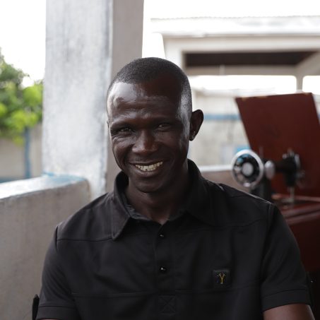 Man in a black shirt smiling at the camera