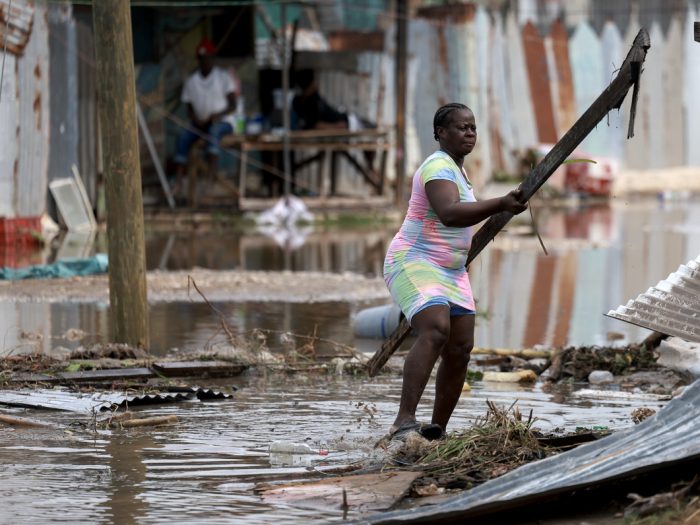 Woman moving rubble after Hurricane Beryl struck the Caribbean