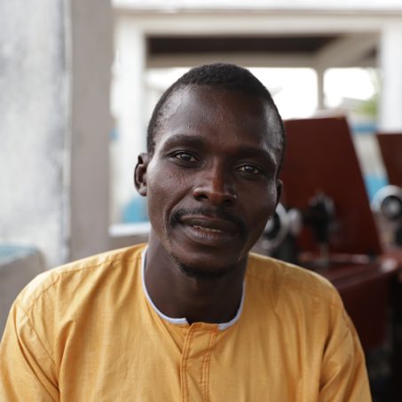 Man in yellow smiling at the camera