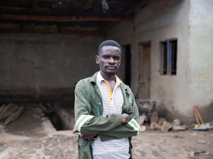 Man standing outside a damaged building in Malawi