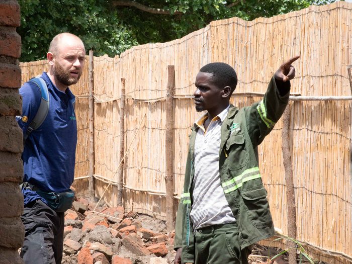 Two men waking round damaged building in Malawi