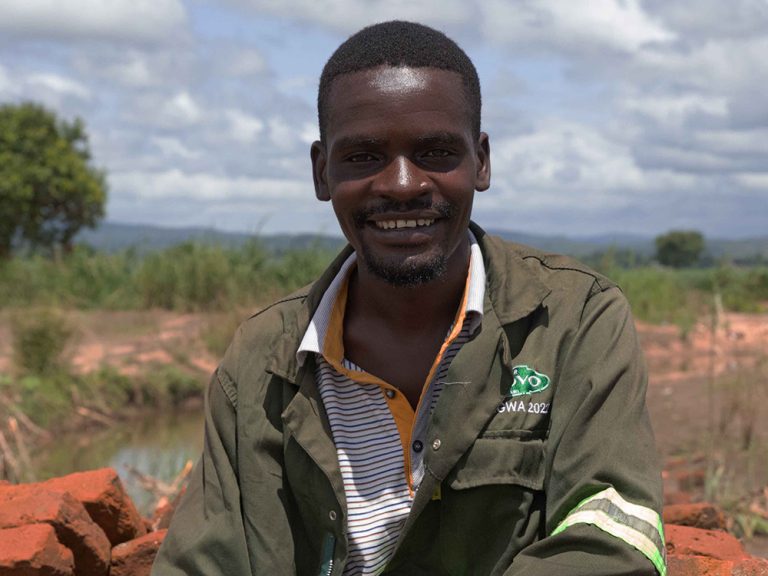 Man sitting on a pile of bricks in Malawi