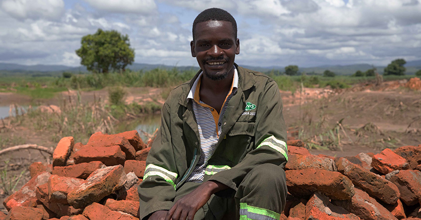 Man sitting on a pile of bricks in Malawi