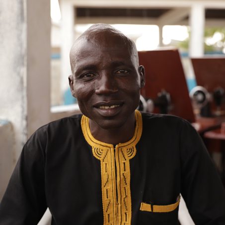 Man in brown and yellow smiling at the camera