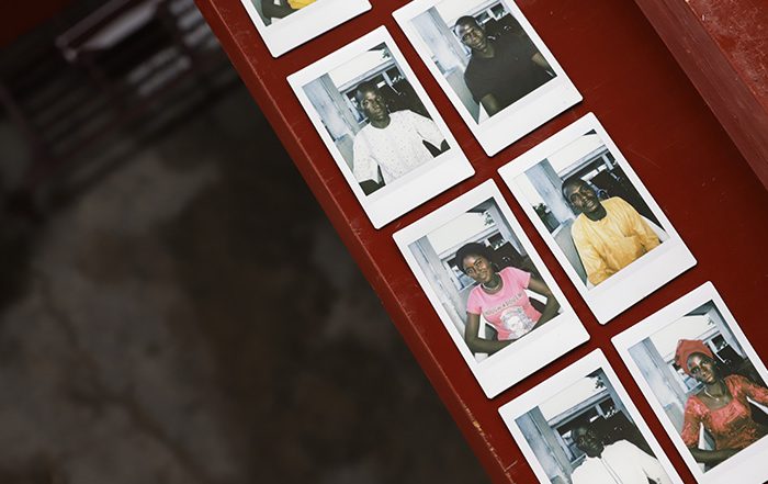 Polaroid photos of people in Cameroon laid out on a table