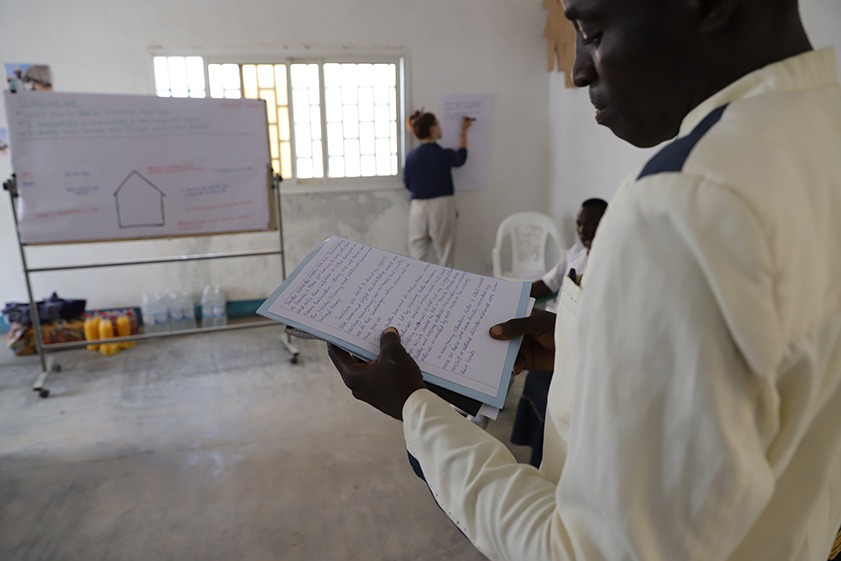 Man reading from notes in a workshop in Cameroon