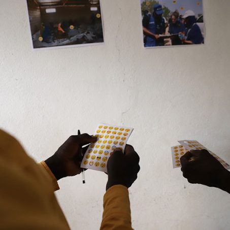 People holding sheets of Emoji stickers