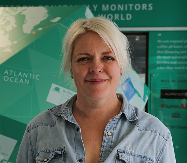 Woman with blonde hair in front of a green background