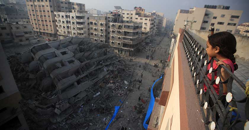 Young girl overlooks bombed building in Gaza