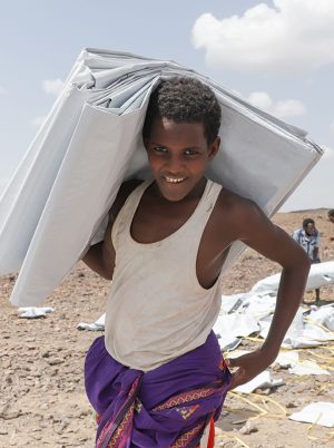 boy carrying a tarpaulin in ethiopia