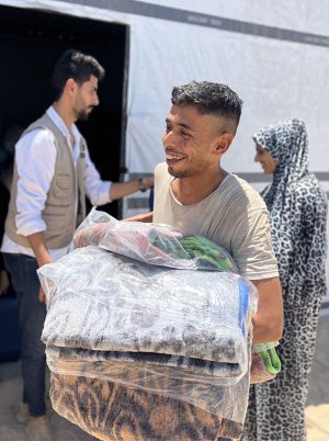 man carrying shelterbox aid in gaza