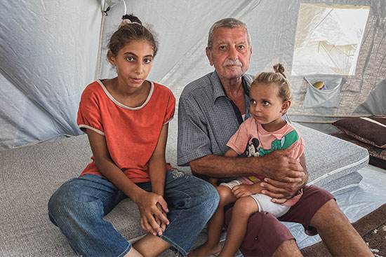 Family sitting on a mattress in Gaza