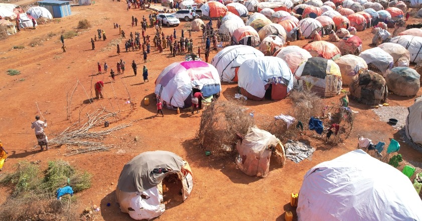 A cluster of shelters atop red sand